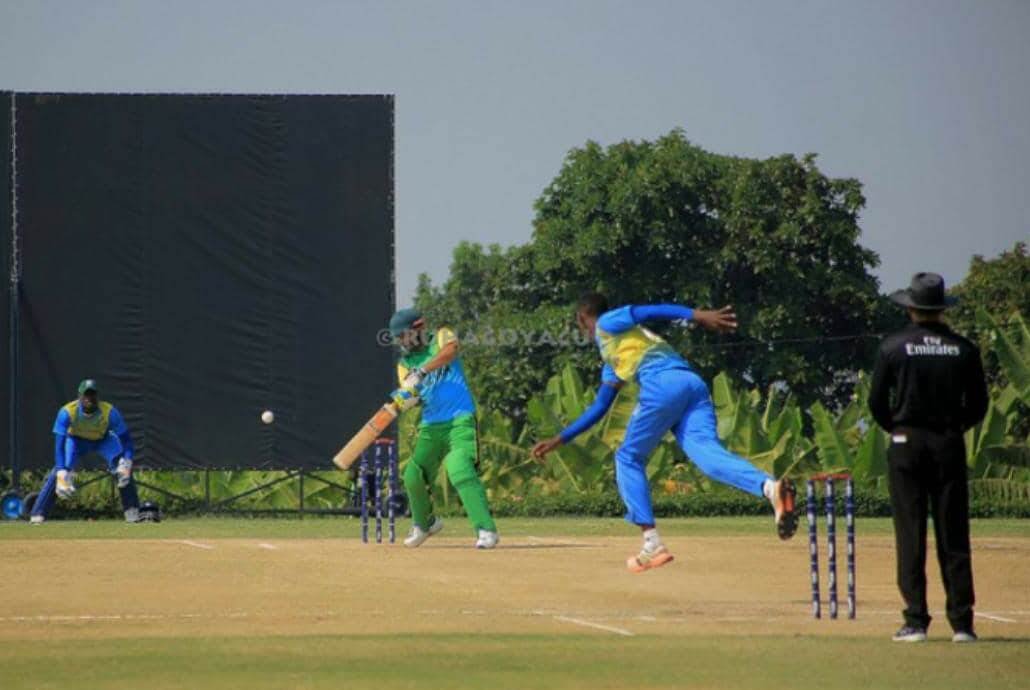 A fast bowler delivering a cricket ball