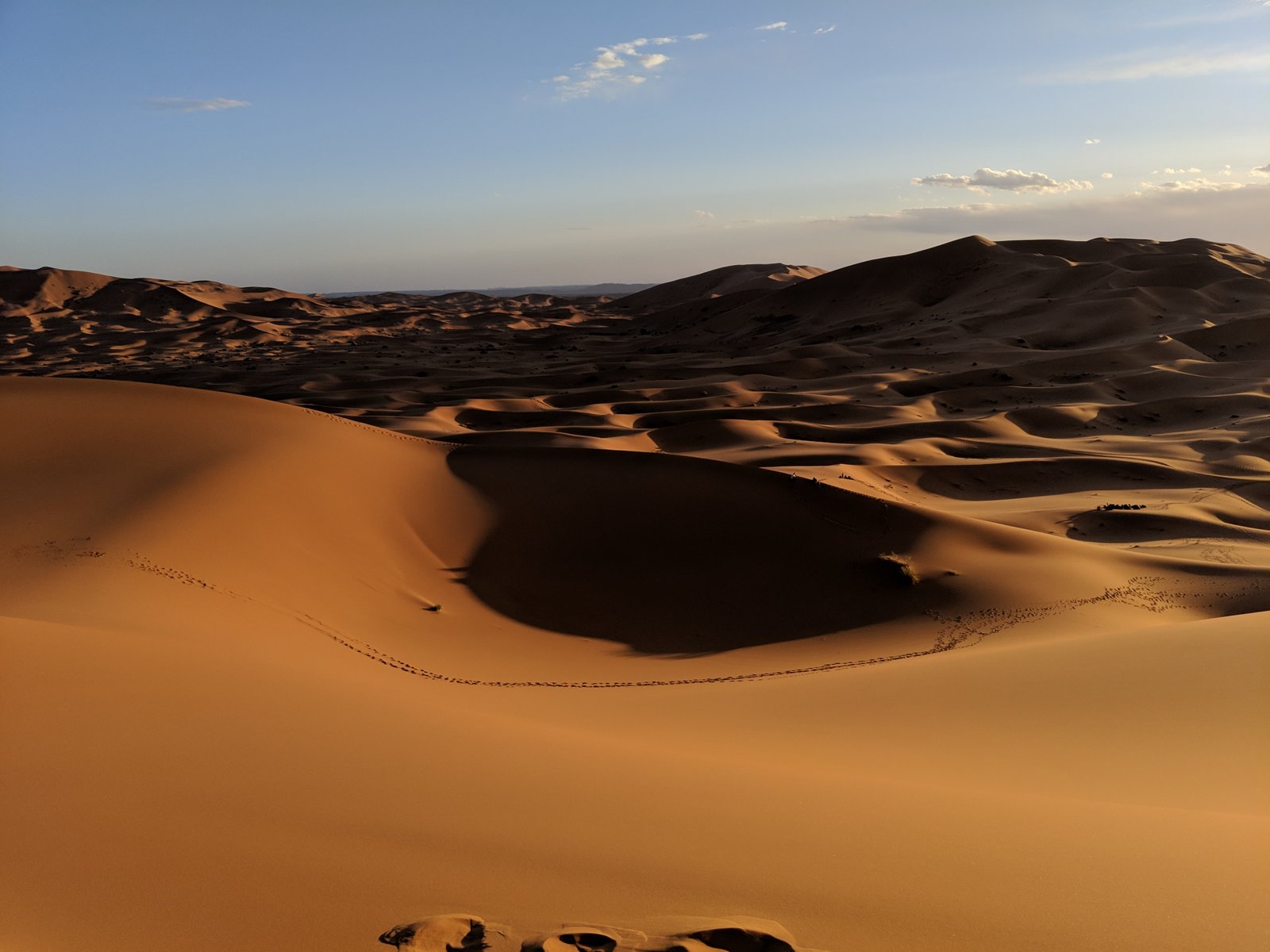 A dramatic desert sunset with wind-blown sand