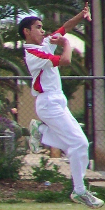 A fast bowler delivering a cricket ball
