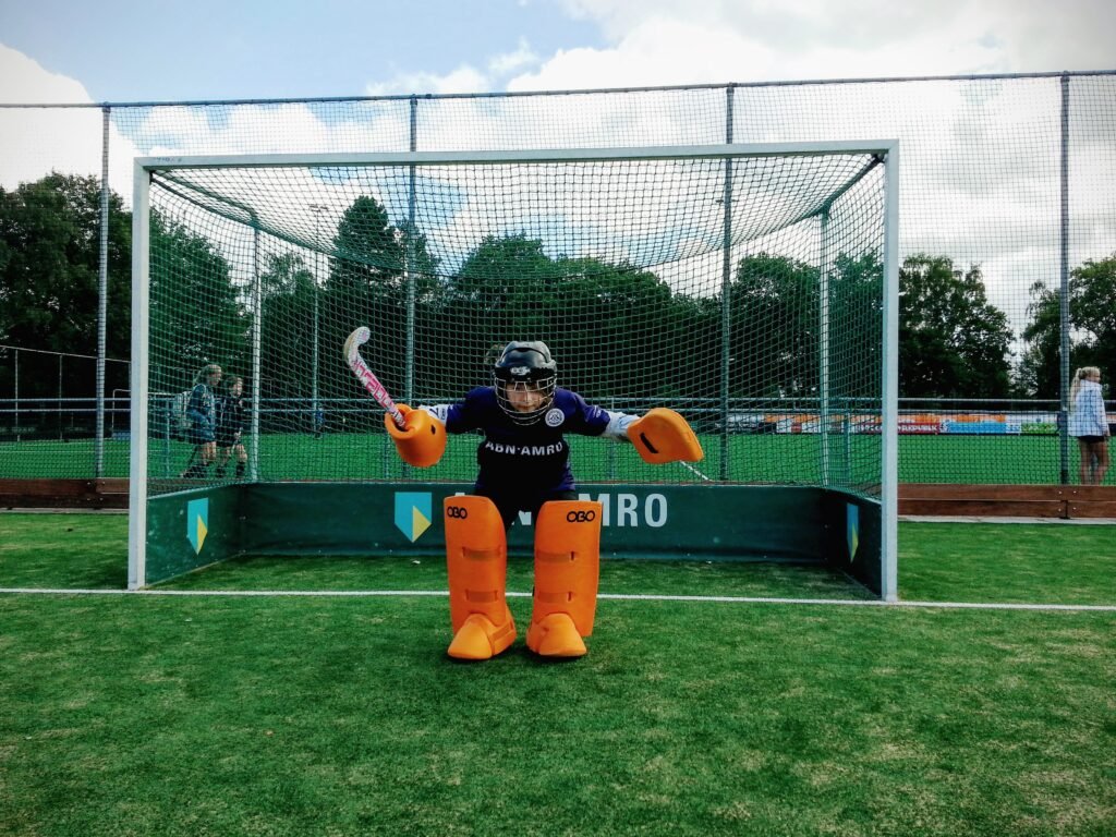 Field hockey goalkeeper facing an attacker in a one-on-one shootout-style attempt