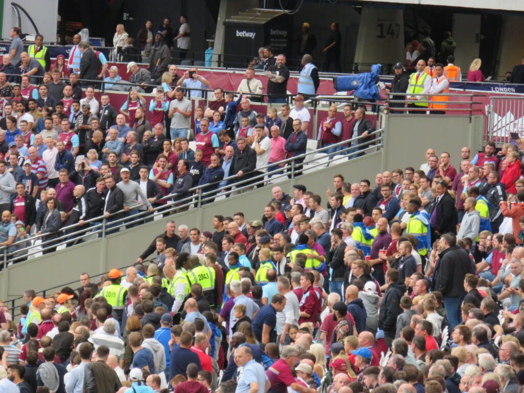 Football fans in a packed stadium stand