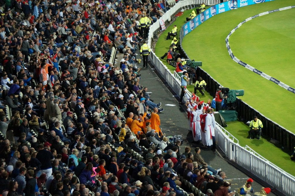 Cricket fans in a stadium watching a match