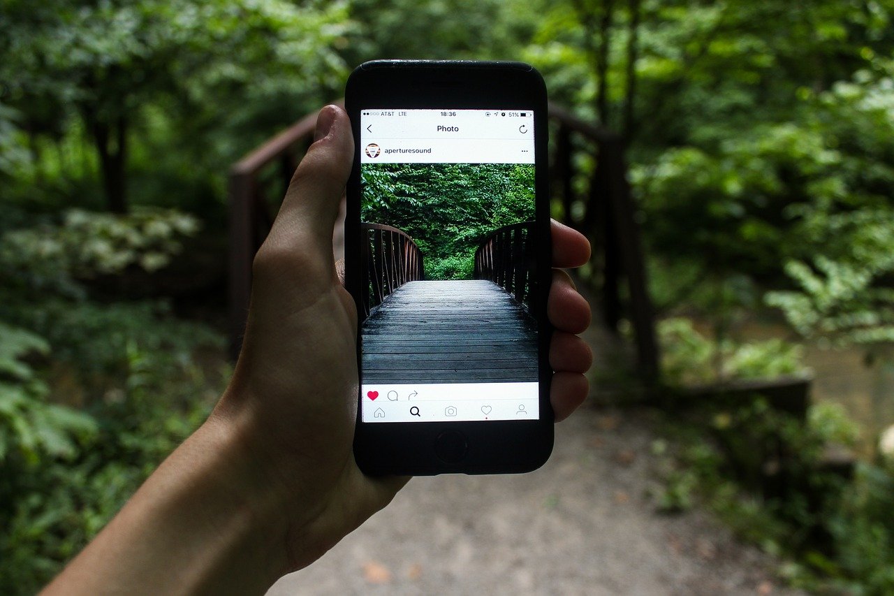 Hand holding an iPhone — Apple Intelligence features coming to China in December (CC0: Jeremy Levin, Wikimedia Commons)