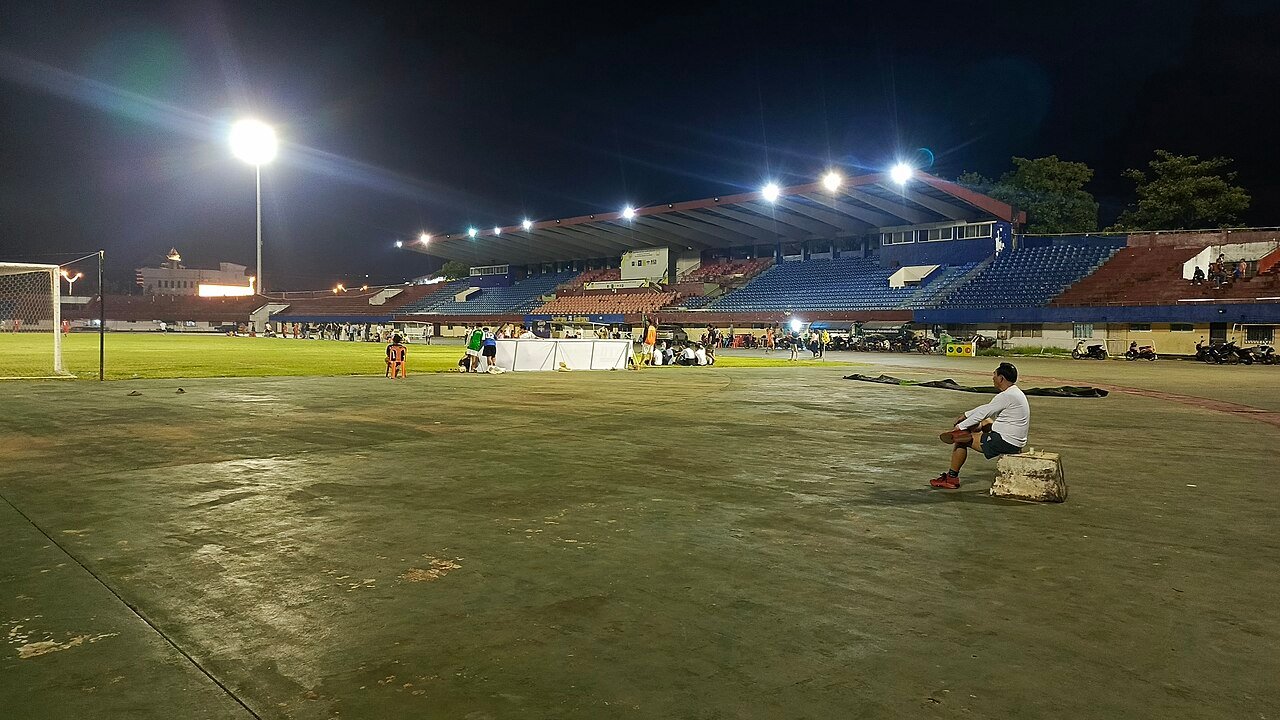 Football stadium under floodlights at night