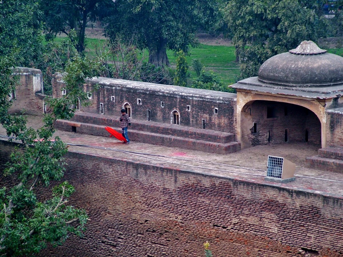 A child carrying a red kite on the ramparts of the Shahi Qila in Lahore