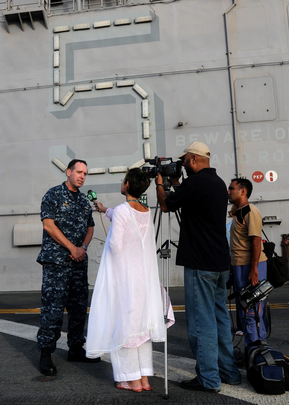 A female Pakistani TV journalist holds a microphone to a U.S. Navy officer while a cameraman films, on the flight deck of the USS Peleliu, 12 August 2010 (archive photo).
