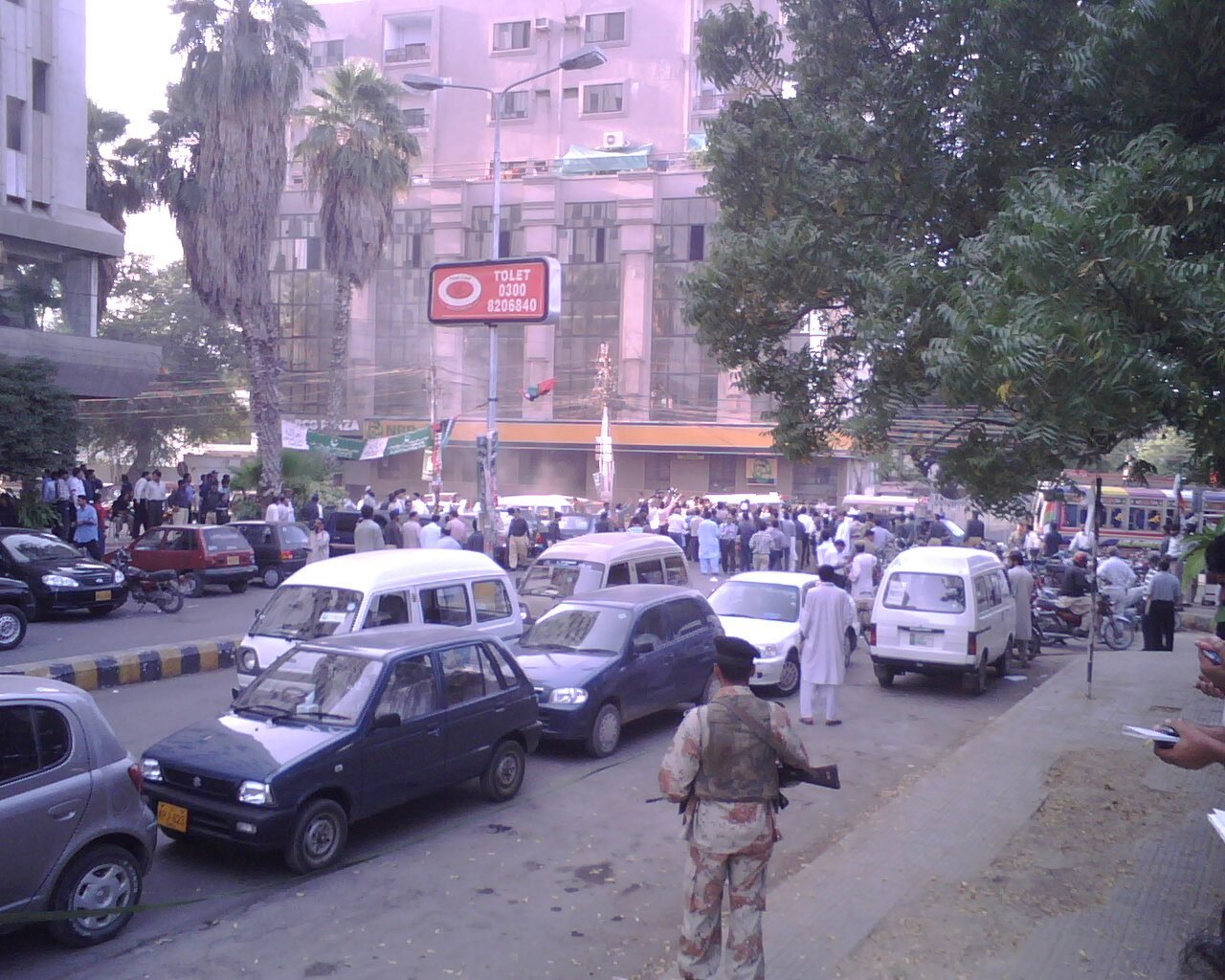 An armed policeman stands among a crowd outside the Karachi Press Club on 5 November 2007 (archive photo).