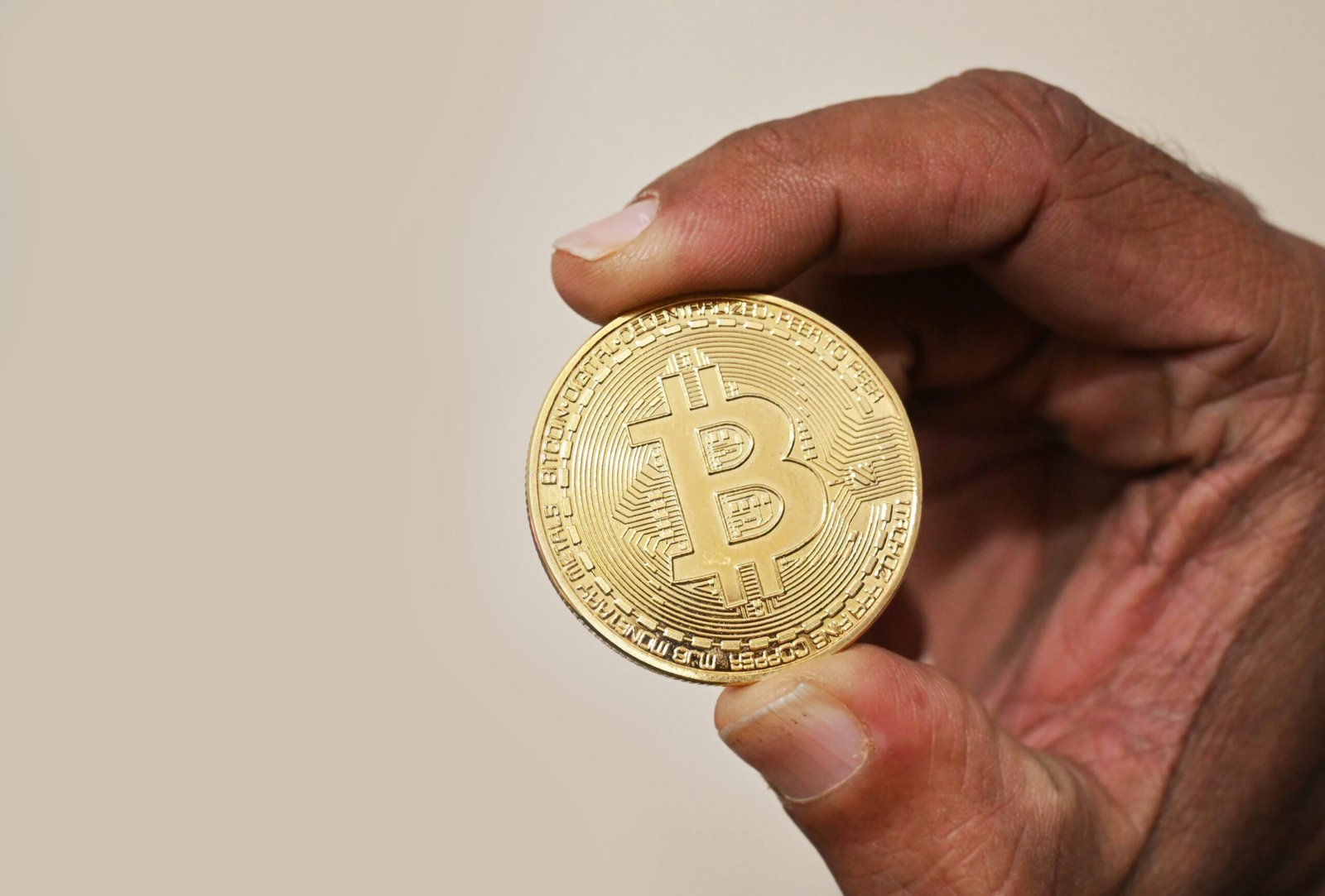 A Bitcoin token held in hand — Pakistan reversed its 2018 crypto ban with the Virtual Assets Act 2026