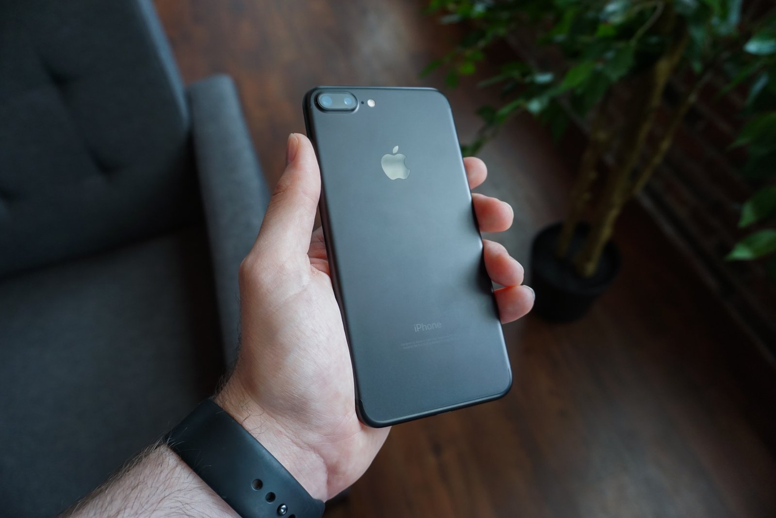 A black smartphone held in a hand (File photo)