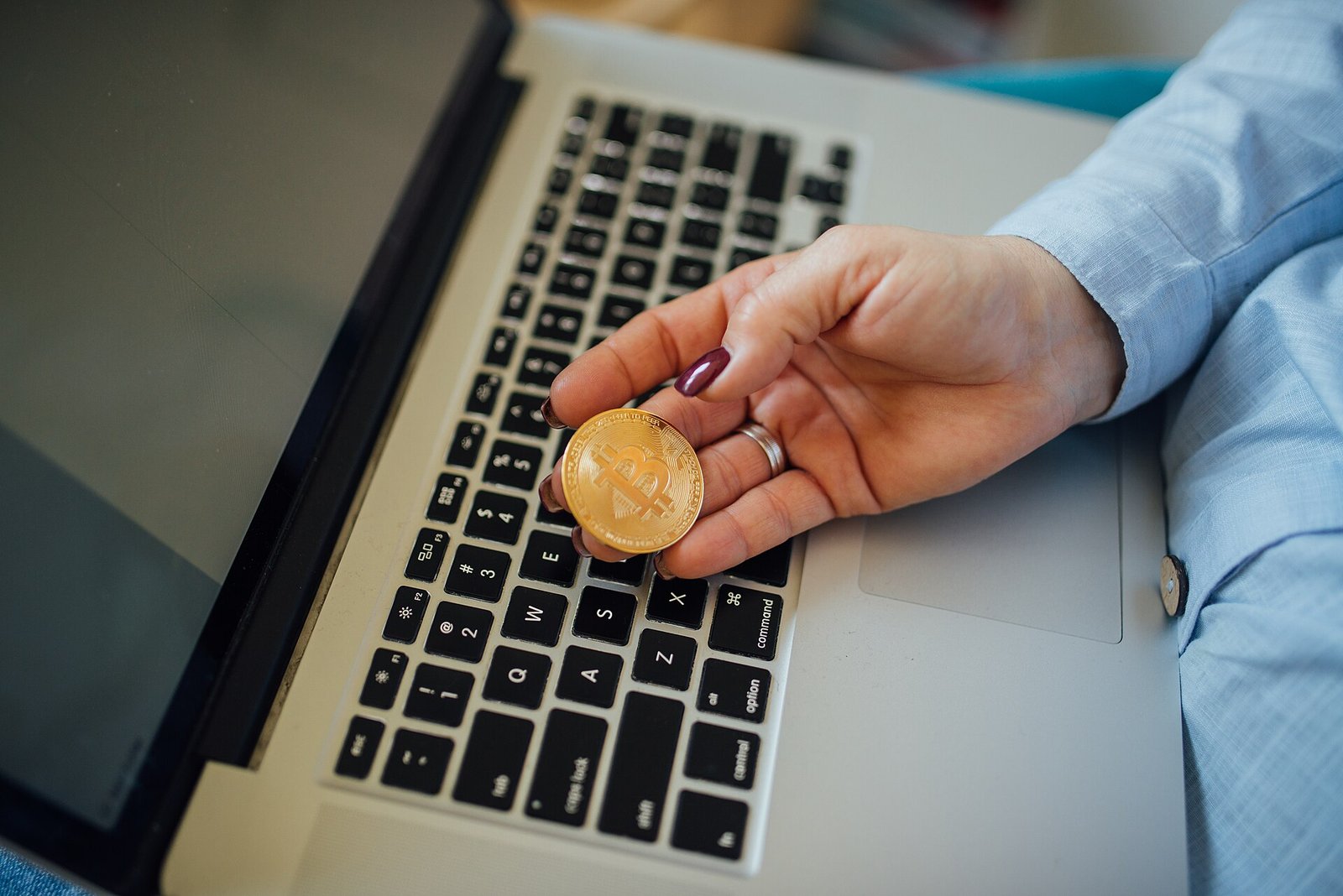 A physical bitcoin held over a laptop; Pakistan has one of the world's fastest-growing crypto user bases (File photo)