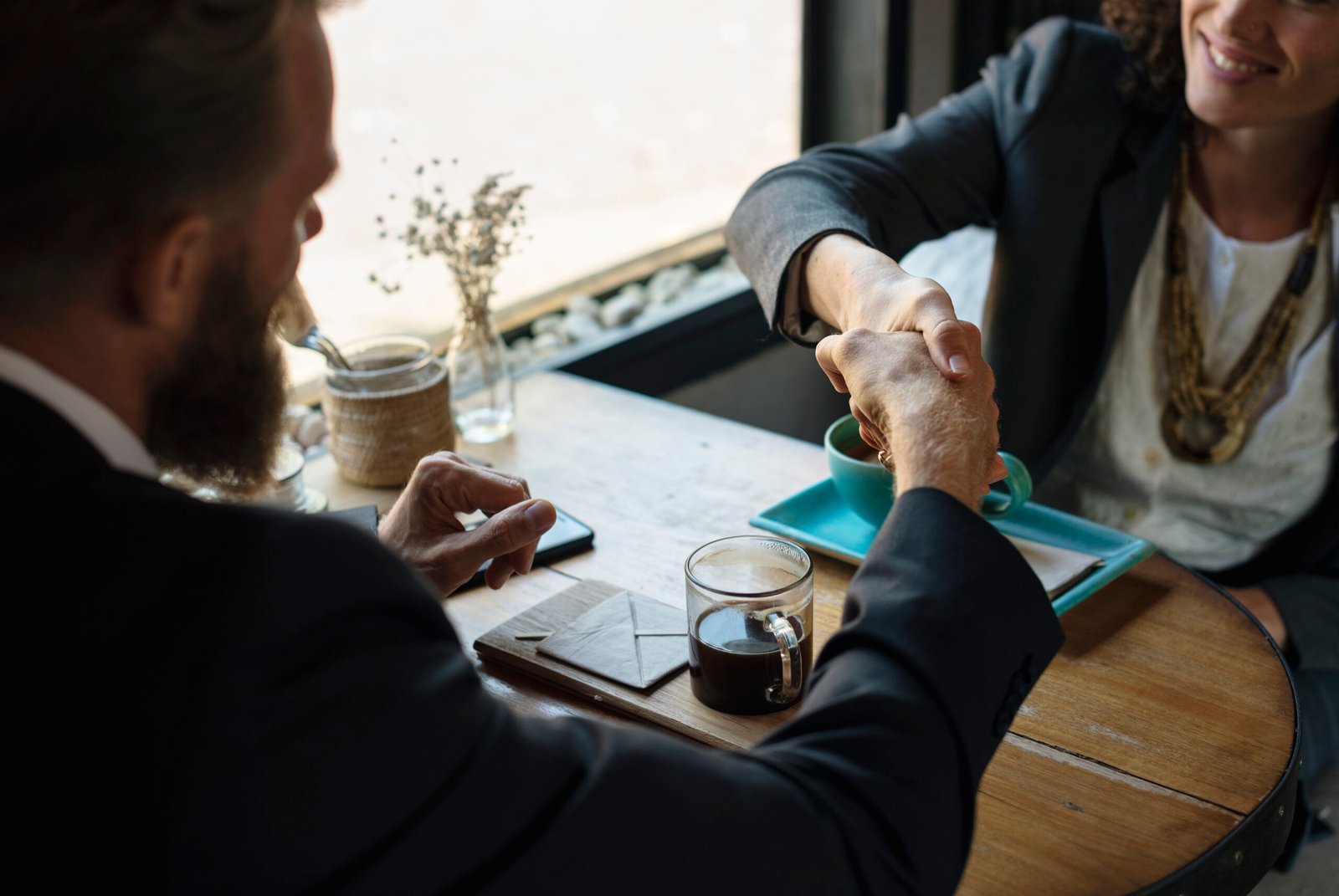 Two business people shaking hands over a business agreement — representative photo.