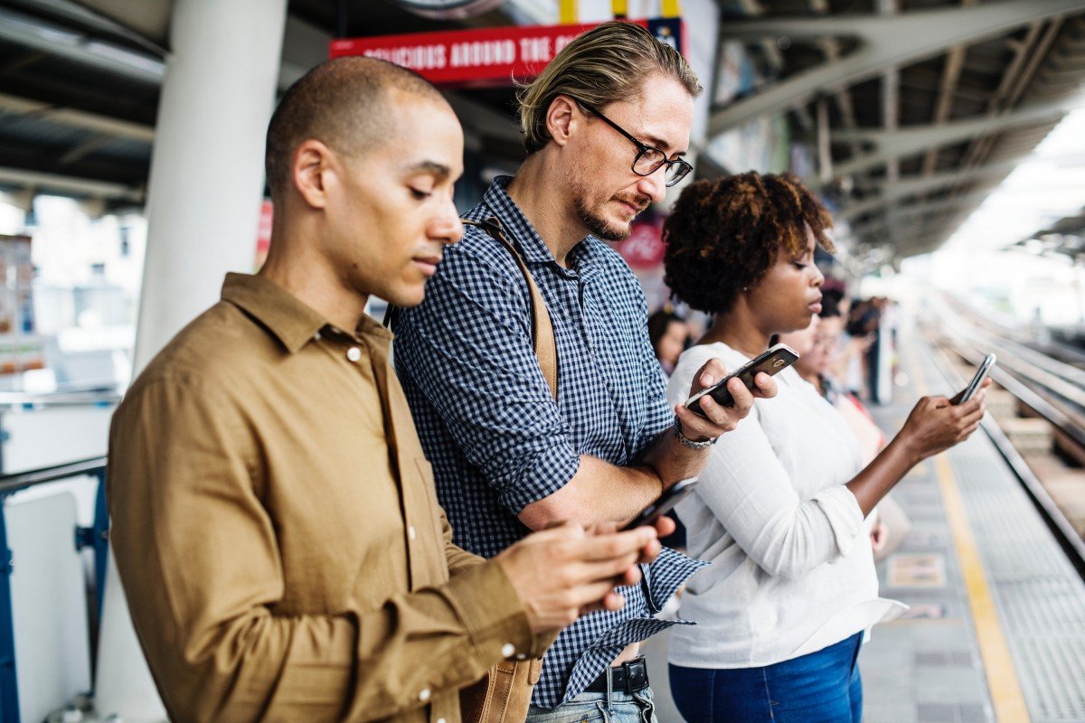 People using smartphones while commuting (file photo)