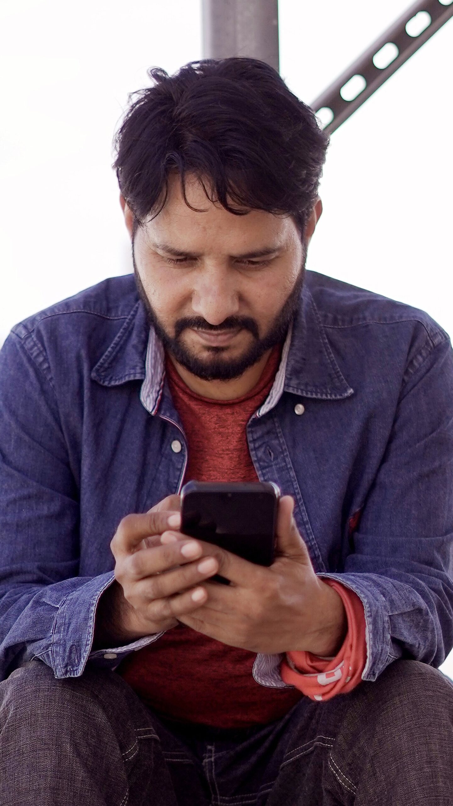 A man checking his smartphone outdoors (representative photo)